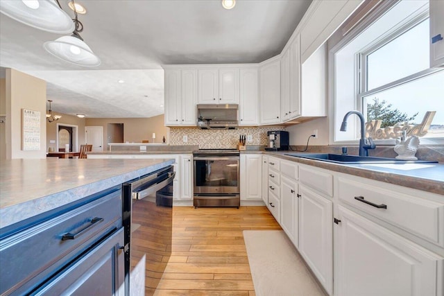 kitchen featuring sink, white cabinetry, stainless steel range with electric stovetop, pendant lighting, and light hardwood / wood-style floors