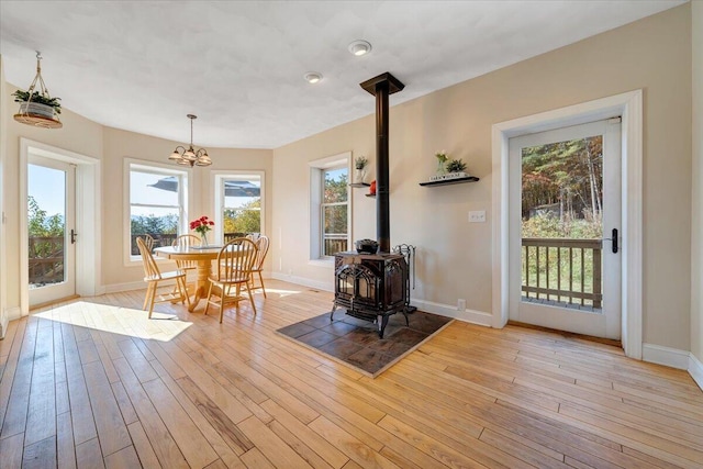 dining area with light wood-type flooring and a wood stove