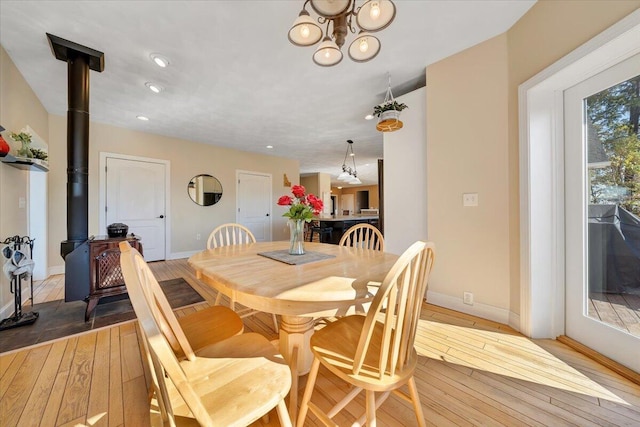 dining area with a wood stove and hardwood / wood-style floors