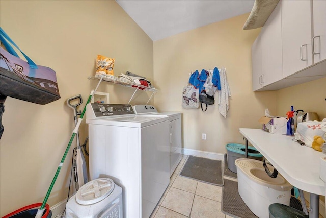 laundry room with cabinets, washing machine and clothes dryer, and light tile patterned flooring