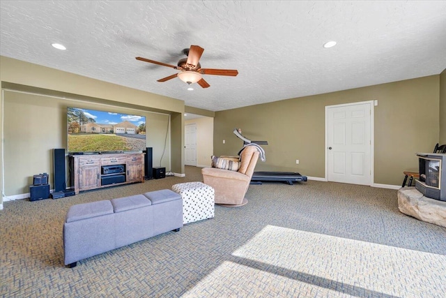 carpeted living room with ceiling fan, a fireplace, a textured ceiling, and a wood stove