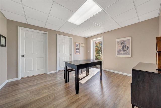 office area with a paneled ceiling and light wood-type flooring