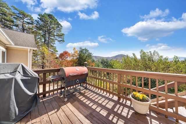 wooden deck featuring a mountain view and area for grilling