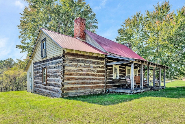 exterior space with covered porch and a yard