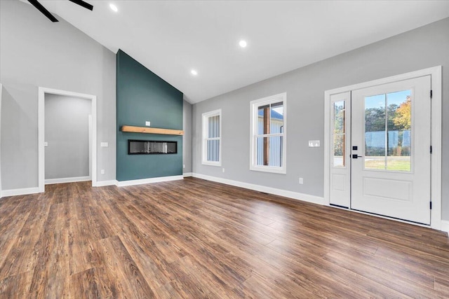 unfurnished living room featuring high vaulted ceiling, dark wood-type flooring, and ceiling fan