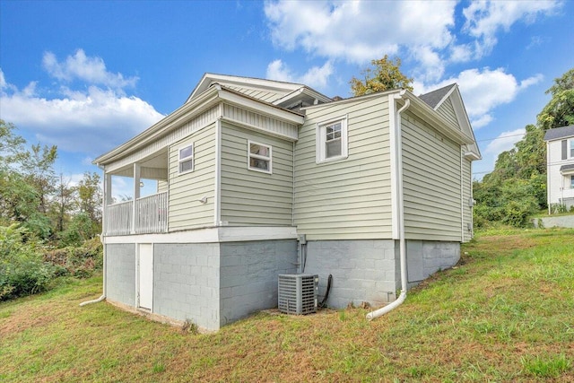 view of side of home featuring central AC and a yard