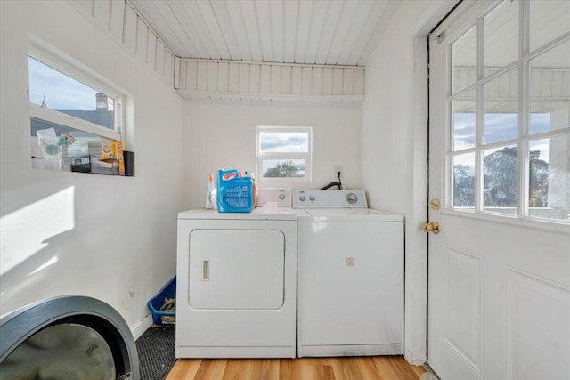 laundry area with light wood-type flooring and washing machine and clothes dryer