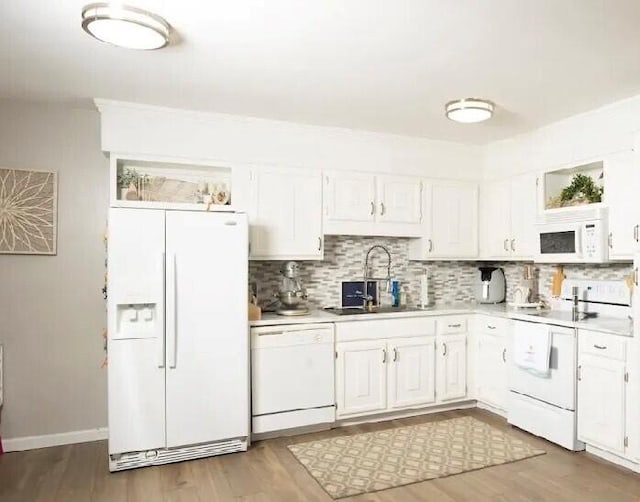 kitchen with white cabinetry, hardwood / wood-style flooring, sink, and white appliances