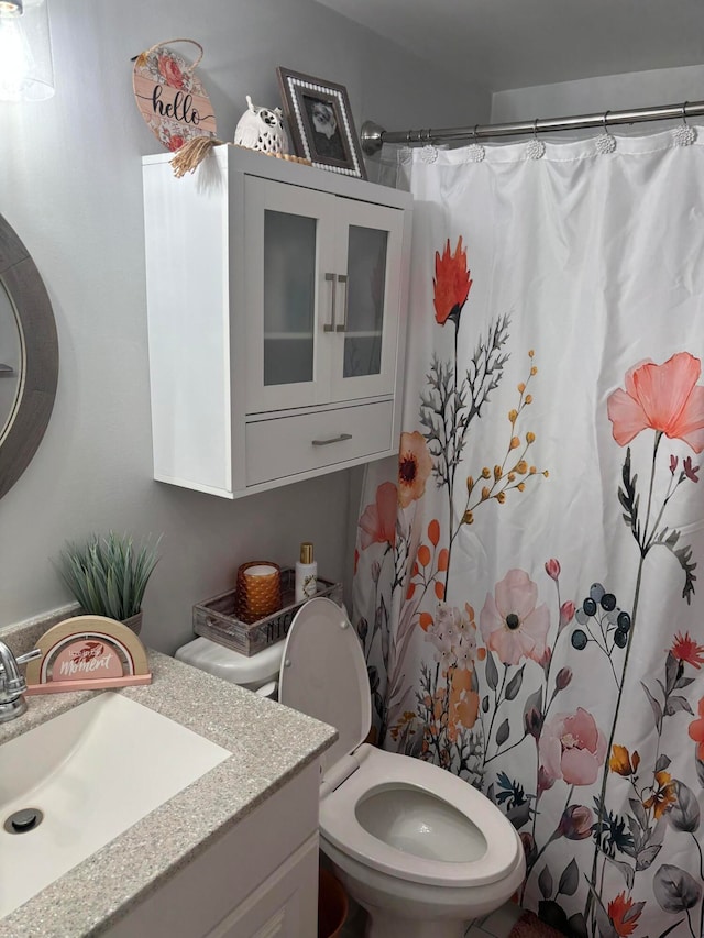 bathroom with vanity, curtained shower, and toilet