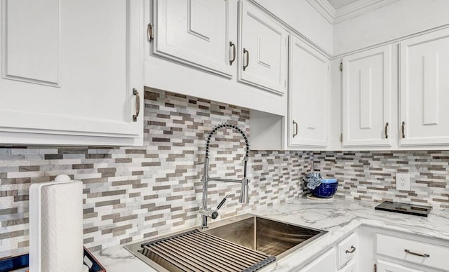 kitchen featuring ornamental molding, sink, white cabinets, and tasteful backsplash