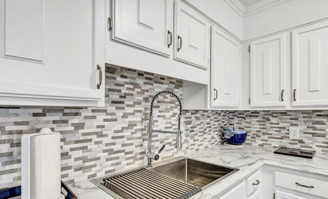 5260 Crossbow Cir Unit 3D, Roanoke, VA 24018 - kitchen featuring a sink, backsplash, white cabinetry, ornamental molding, and light stone counters