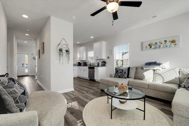 living room featuring dark hardwood / wood-style flooring, sink, and ceiling fan