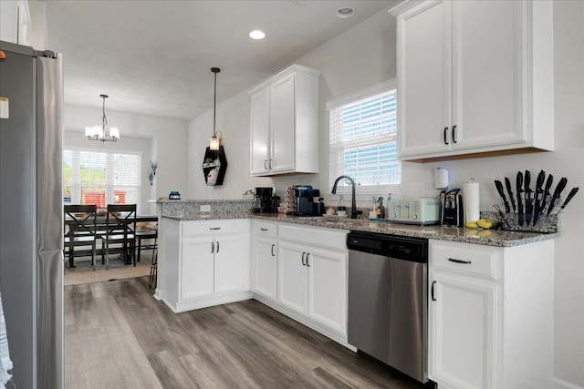 kitchen with stainless steel appliances, plenty of natural light, white cabinetry, and kitchen peninsula