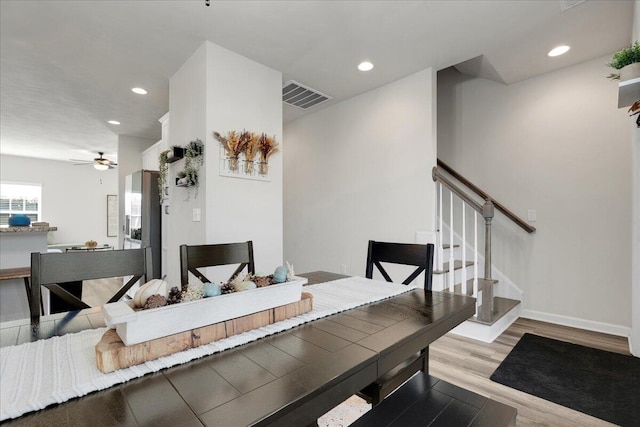 dining space with ceiling fan and light hardwood / wood-style flooring