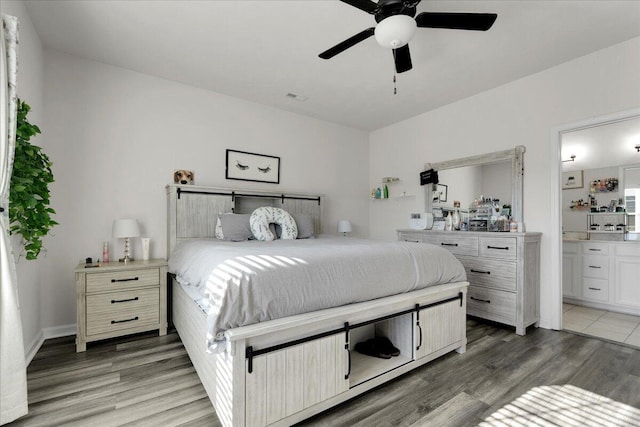 bedroom featuring connected bathroom, ceiling fan, and dark hardwood / wood-style floors