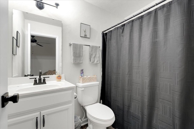 bathroom featuring a shower with curtain, ceiling fan, vanity, and toilet