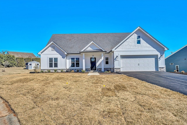 modern farmhouse style home with driveway, a shingled roof, an attached garage, a front lawn, and board and batten siding