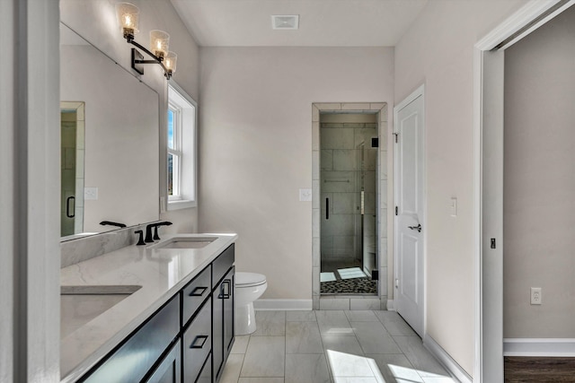 bathroom featuring visible vents, toilet, a sink, a shower stall, and baseboards