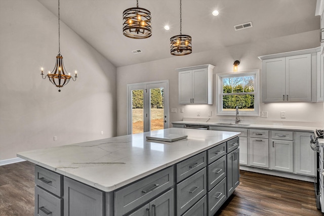 kitchen featuring a center island, visible vents, a sink, and gray cabinetry