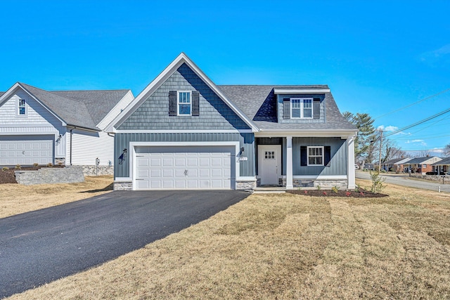 view of front of property featuring driveway, a garage, a front lawn, and board and batten siding