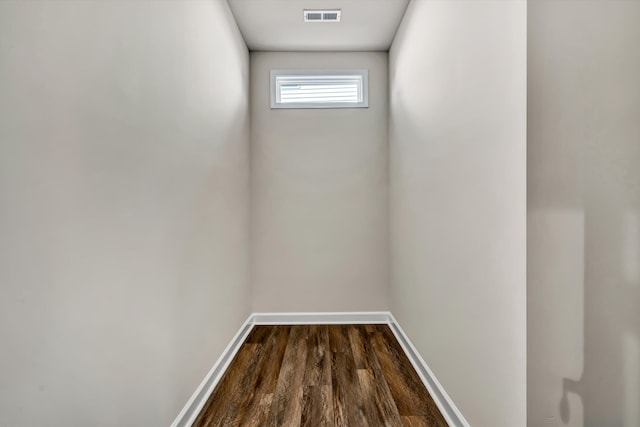 interior space with dark wood-type flooring, visible vents, and baseboards