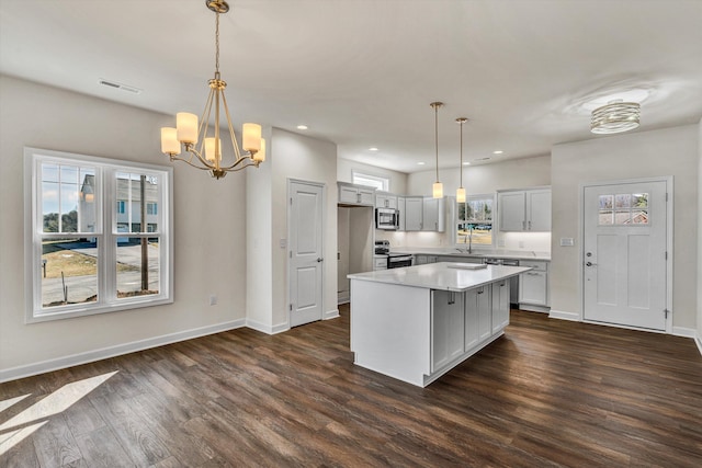 kitchen featuring dark wood-style floors, baseboards, appliances with stainless steel finishes, and light countertops