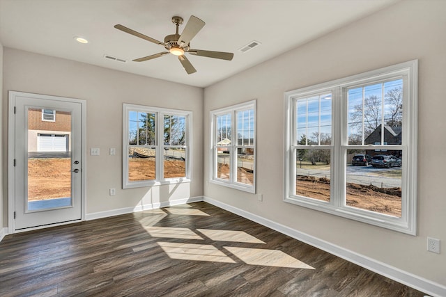 unfurnished sunroom featuring visible vents and ceiling fan