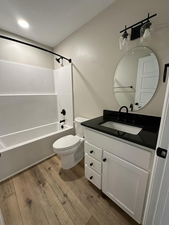 full bathroom with vanity, toilet, hardwood / wood-style floors, and  shower combination