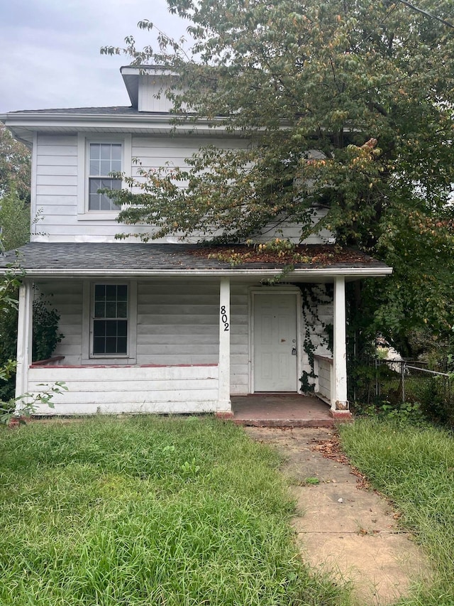 view of front of property with covered porch and a front yard