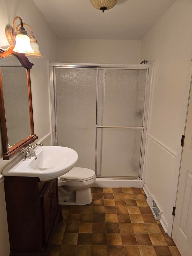 bathroom with vanity, a shower with shower door, and toilet