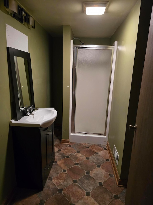 bathroom featuring vanity and a shower with door