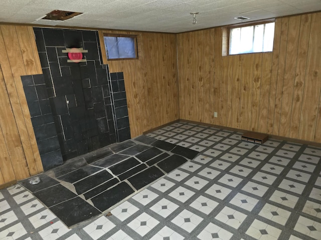 basement with a textured ceiling and wood walls