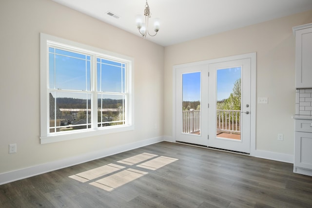 6913 Doral Dr, Radford, VA 24141 - unfurnished dining area featuring dark wood finished floors, baseboards, a chandelier, and visible vents