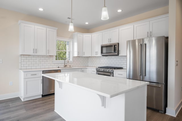 6913 Doral Dr, Radford, VA 24141 - kitchen featuring a center island, a sink, high end appliances, decorative backsplash, and white cabinets