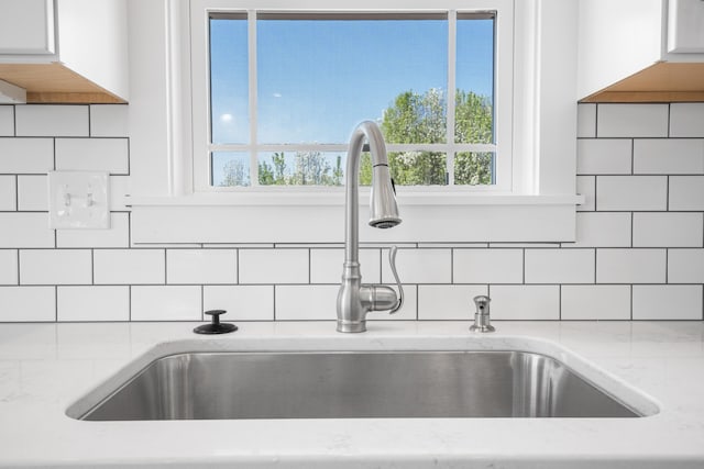 6913 Doral Dr, Radford, VA 24141 - interior details with white cabinets, backsplash, light stone counters, and a sink
