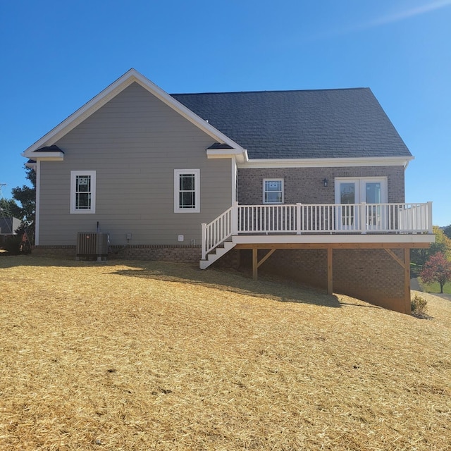 back of property with cooling unit, a deck, and a yard