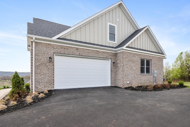 6913 Doral Dr, Radford, VA 24141 - view of property exterior with board and batten siding, brick siding, aphalt driveway, and roof with shingles