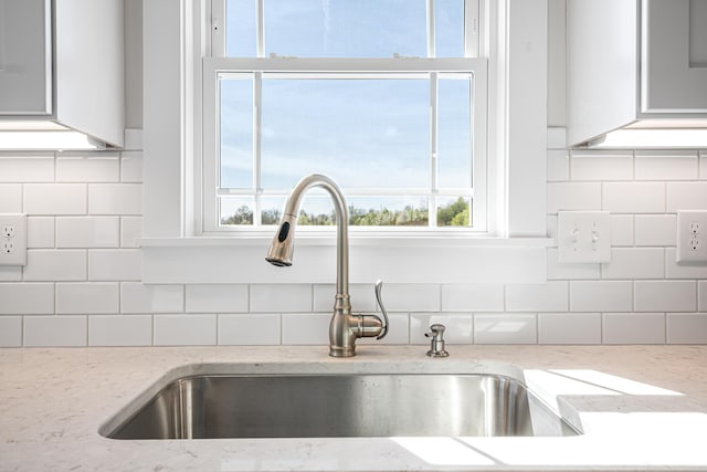 6903 Doral Dr, Radford, VA 24141 - interior details featuring white cabinets, tasteful backsplash, light stone countertops, and a sink