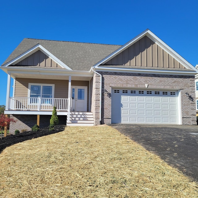 view of front of house with a porch, a front lawn, and a garage