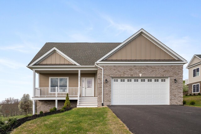 6903 Doral Dr, Radford, VA 24141 - view of side of home featuring aphalt driveway, a yard, board and batten siding, brick siding, and a garage