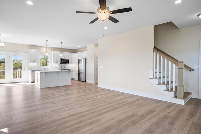 6903 Doral Dr, Radford, VA 24141 - unfurnished living room featuring recessed lighting, light wood-style flooring, and ceiling fan with notable chandelier