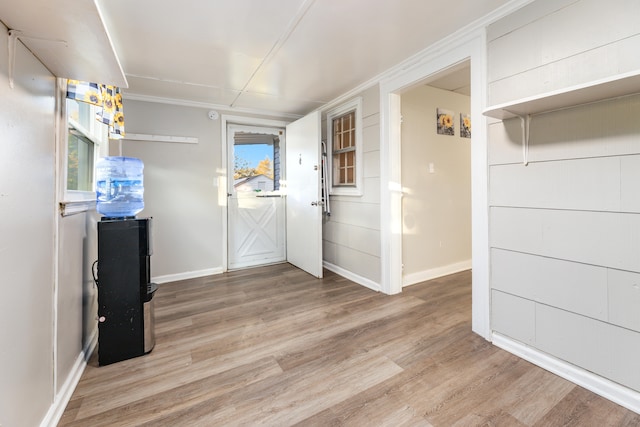 kitchen with plenty of natural light, ornamental molding, and light wood-type flooring