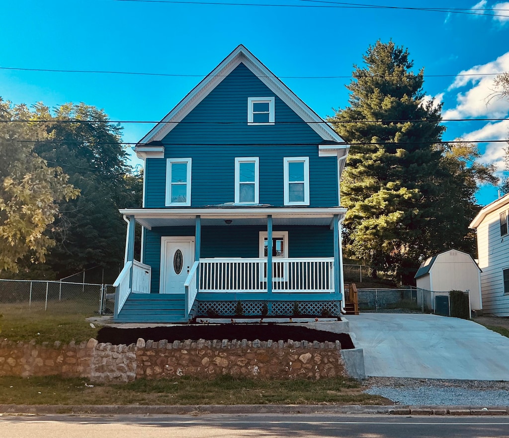 view of property with a shed and covered porch