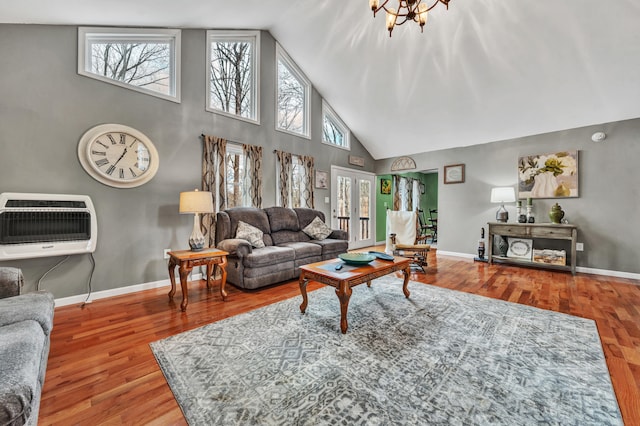 living room featuring hardwood / wood-style flooring, high vaulted ceiling, heating unit, and a wealth of natural light