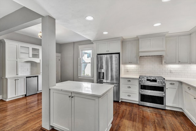 kitchen featuring white cabinetry, light stone counters, stainless steel appliances, and dark hardwood / wood-style floors