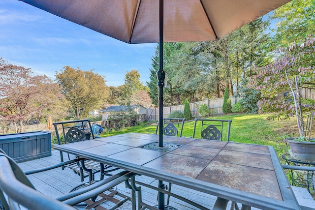 view of patio / terrace featuring a jacuzzi and a storage unit