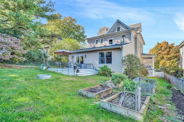 back of property featuring a yard and a deck