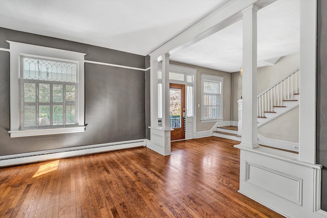 entrance foyer featuring a baseboard heating unit, wood-type flooring, and decorative columns