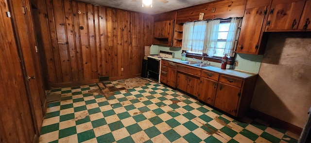 kitchen with sink, white range with electric stovetop, ceiling fan, and wooden walls