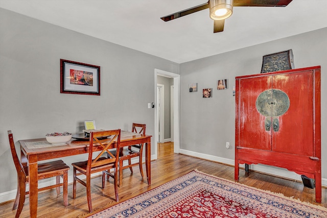 dining area with wood-type flooring and ceiling fan